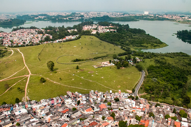 Vista aérea de uma área urbana ao lado de uma grande área verde