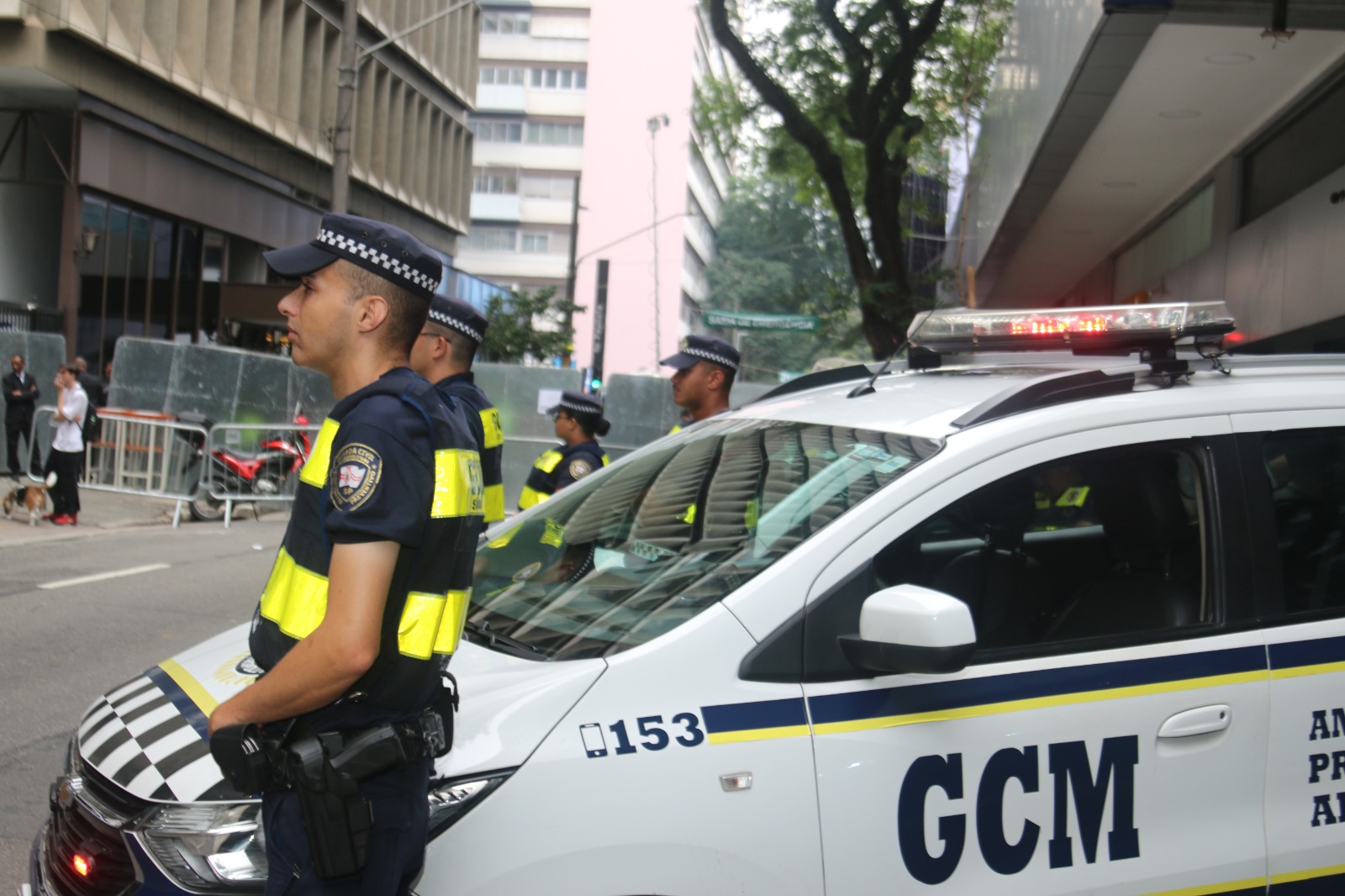 A imagem mostra um viatura da Guarda Civil Metropolitana e guardas ao redor