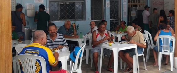 #PraCegoVer Várias pessoas almoçam em Cozinha Escola na região do Jaraguá